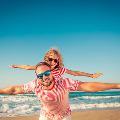Happy family on the beach. People having fun on summer vacation. Father and child against blue sea and sky background. Holiday travel concept