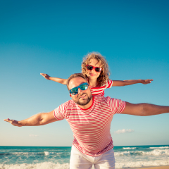 Happy family on the beach. People having fun on summer vacation. Father and child against blue sea and sky background. Holiday travel concept