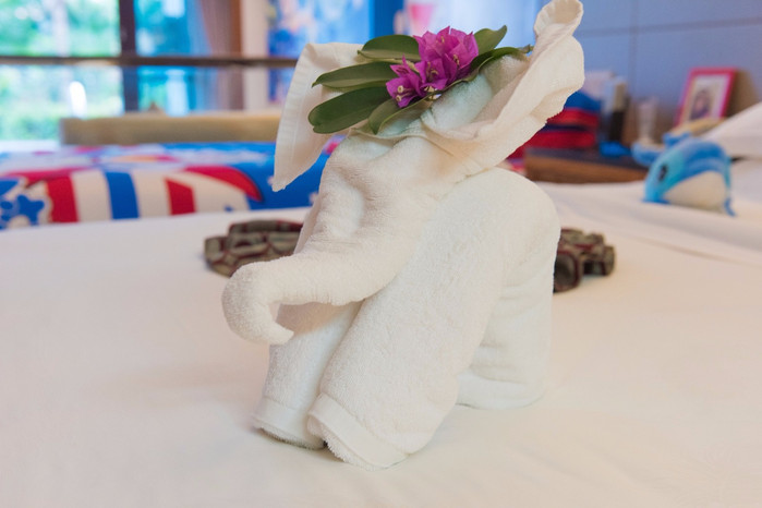 床上的毛巾被叠成了一个小象的形状,有一种东南亚的感觉