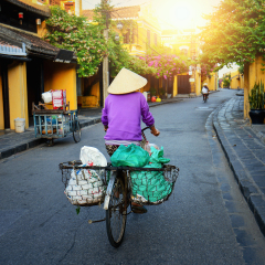 Vietnam people,Vietnamese ride bicycle on during sunrise,woman with Vietnam culture traditional,Morning view of busy street in Hoi An, Hoi An is the World's Cultural heritage site ,Hoi an, Vietnam