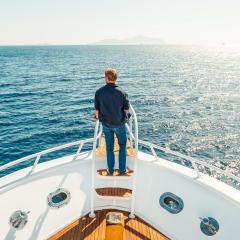 Man on a yacht. Beautiful view from a bow of yacht at seaward. Sailing. Luxury yachts. Boats in sailing regatta. Summer vacation and voyage concept