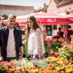 A Smiling Couple Looking Down At Various Flowers Together