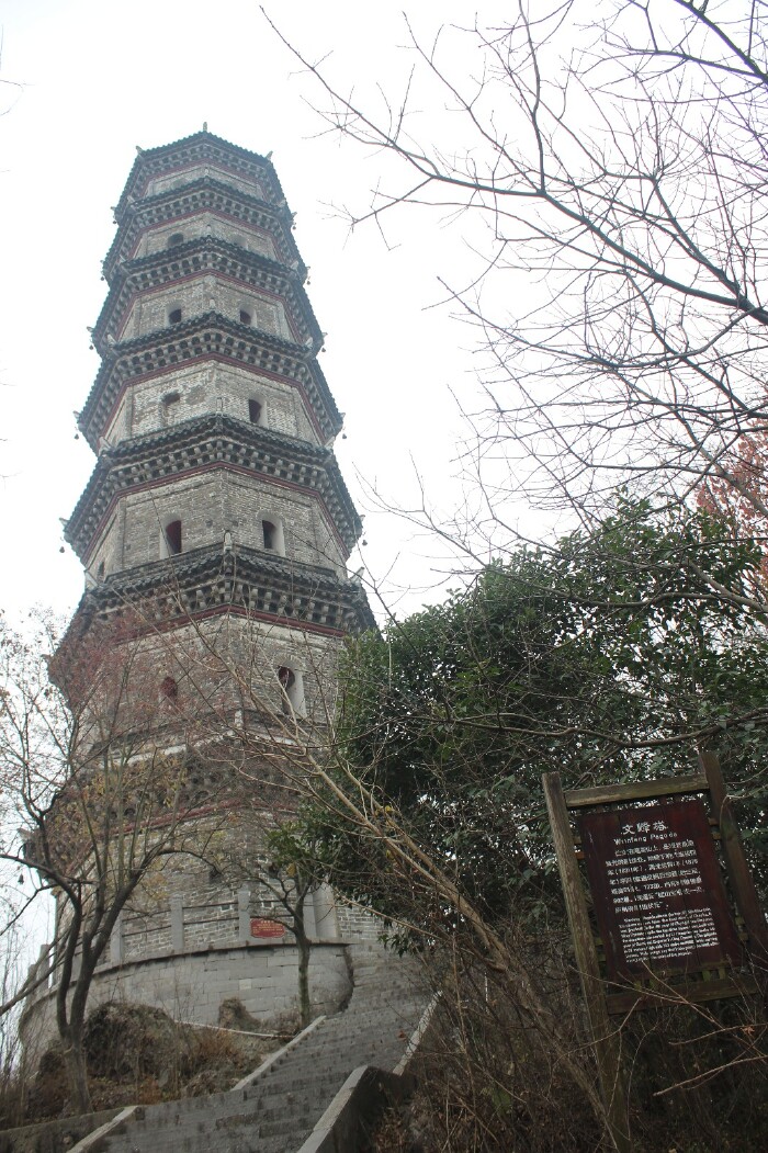 在文峰塔下有一处茶铺,坐着歇息的客人,一位老者在演奏着乐器,完了