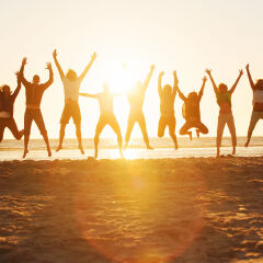 Young people jumping at the beach of St.Peter-Ording in Germany