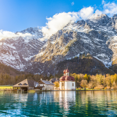 Panoramic view of scenic mountain scenery with Lake Konigssee with famous Sankt Bartholomae pilgrimage church in golden evening light in fall, national park Berchtesgadener Land, Bavaria, Germany