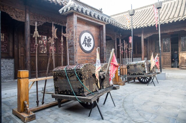 摆放有刀枪剑戟,斧钺钩杈等十八般长短兵器,以及押镖"三宝":镖旗,镖箱