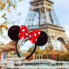 PARIS - November, 11, 2015: Closeup on Minnie Mouse Ears in female hand on embankment near Eiffel tower in Paris, France