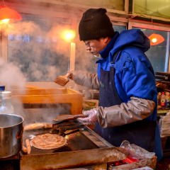 HARBIN,CHINA - JAN 02: Unidentified chef makes a chinese crepe in cold weather on January 02,2015 in Harbin ,China.