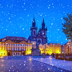 Prague, Czech Republic Central Old Town square in old town. Night view at Church of Our Lady Before Tyn with nighttime illumination. Christmas holiday. Winter snowfall and blue sky.