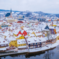 Panoramic view of Cesky Krumlov in winter season, Czech Republic. View of the snow-covered roofs. Travel and Holiday in Europe. Christmas and New Year time. Sunny winter day in european town.