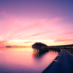 Panorama sunset on Maldives island, water villas resort. Beautiful sky and clouds. Beautiful beach background for summer travel with sun, beach wooden jetty. Summer mood sun beach background concept.