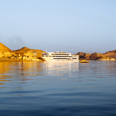Lake Nasser, Egypt - August 17, 2006: Luxury cruise ship at lake Nasser. The statue of Ramses II, at Abu Simbel Temple, look out over Lake Nasser and tourists can enjoy the view from their cruise ship