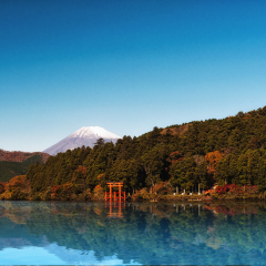 Red torii gate on the shore of Lake Ashi, near Mount Fuji in Hakone, Japan.