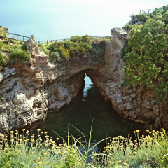 Bay called Bagni della Regina Giovanna at Capo di Sorrento with natural rock bridge, Italy