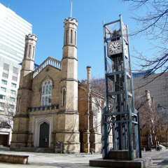 Clock and Anglican Church of Holy Trinity at Trinity Square in Toronto, Canada