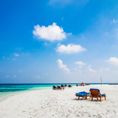 Tropical island vacation image, white sand beach and sun beds