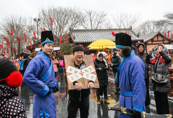 《快乐的囚徒》   这是为了增加气氛,由游人扮的囚徒,大枷扛上,封条贴