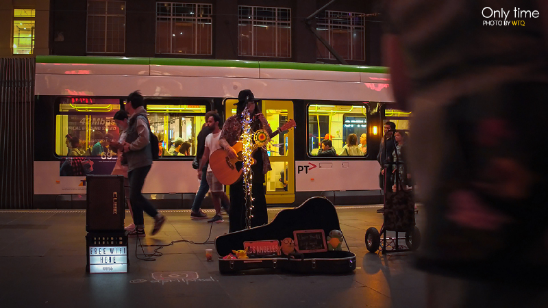 hm商店的门口,一位亚裔面孔的青年在穿梭的人群中专注着他的演出.