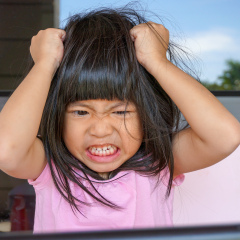 Angry Asian cute girl screaming after her mother take a tablet away. Stressed child,
Kid  with attention deficit hyperactivity disorder (ADHD) can't handle her emotion.

