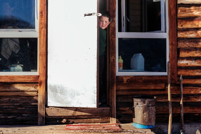 被阳光染得有些晃眼的铁皮门突然开了,一个小朋友探出了头,想必听到了