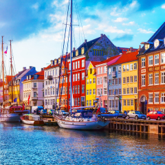 Scenic summer sunset view of Nyhavn pier with color buildings, ships, yachts and other boats in the Old Town of Copenhagen, Denmark