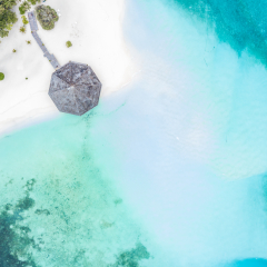 Aerial top view tropical island white sand beach with blue lagoon in Maldives island, Beautiful tropical maldives resort hotel.