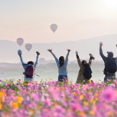 Young Asian tourists  Jumping in Fields of Cosmos and Hot Air Balloons .Travel concept .