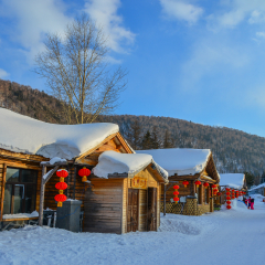 Harbin, China - Feb 24, 2018. Wooden houses with red lanterns in snow at mountain township in Harbin, China.