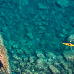 Top view of kayak boat in shallow turquoise water of Ligurian sea, Italy