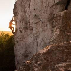 A Silhouette of a Woman rock climbing on Ontario's Niagara Escarpment in Canada
