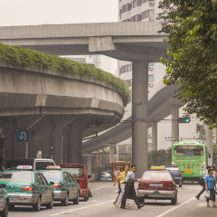 GUANGZHOU, GUANGDONG PROVINCE, CHINA - OCTOBER 12, 2006: People and taxis under elevated highways in city of Guangzhou.