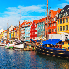 Scenic summer view of Nyhavn pier with color buildings, ships, yachts and other boats in the Old Town of Copenhagen, Denmark