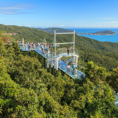 China, Hainan Island - December 1, 2018: Yalong Bay Tropical Paradise Forest Park, Chinese tourists are photographed on the glass suspension bridge, editorial. 