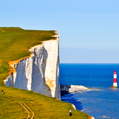 Lighthouse at mountain sea cliff landscape. Mountain sea lighthouse view. Lighthouse mountain sea shore panorama