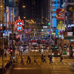 People On City Street Amidst Buildings At Night