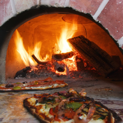 an image of pizza in a wood burning oven