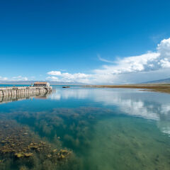 China, Qinghai Lake, Calm waters with view of pier and lakeshore