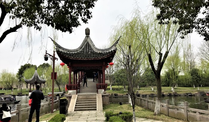 花朵树丛中露出翘角六角亭(独瓦亭)的身形.