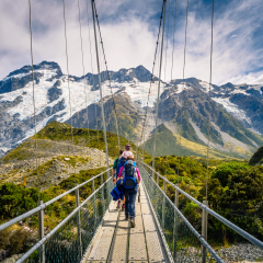 Amazing Nature of Hooker Valley Track in Mount Cook, New Zealand. Young Family walk on Suspension Bridge.
