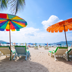 sunbath seats and colorful parasol at Patong Beach in Phuket, Thailand