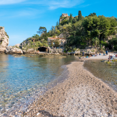 “Isola Bella” Island of Taormina, Sicily. Beautiful  pebbles beach with cliffs and crystal clear water. Hidden paradise island, covered with vegetation, on the coastline of Taormina, Sicily.
