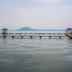 Pavilion in middle of liyuan park at Donghu East lake and Moshan hill in background in Wuhan Hubei China