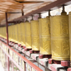 Several golden prayer wheels in a row