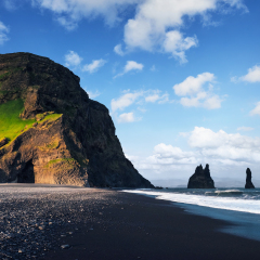 Famous Reynisdrangar rock formations at black Reynisfjara Beach. Coast of the Atlantic ocean near Vik, southern Iceland.
