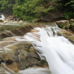 July 2018,Wuyuan, China. Waterfall, flowing water, stream, landscape photo, rocks, long exposure. Water flowing smoothly through rock layers in motion. Close up landscape photo.