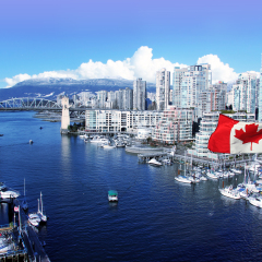 Canadian flag in front of view of False Creek and the Burrard street bridge in Vancouver, Canada. 