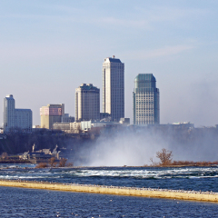 The skyline of Niagara Falls Ontario is shrouded in mist from the waterfall