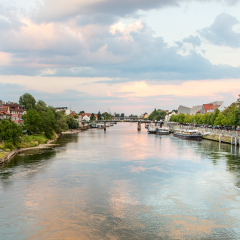 Regensburg, Germany - 26 July, 2018: Beautiful sunset on Danube river. Tourist ships on the water. Medieval architecture of Old Town of Regensburg.