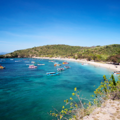 Boats with tourists arriving to beautiful beach on tropical island, Lombok, Indonesia