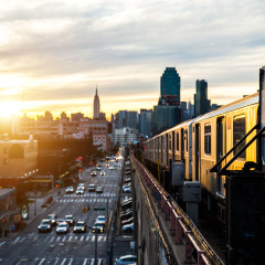 Subway train in New York at sunset and Manhattan cityscape view